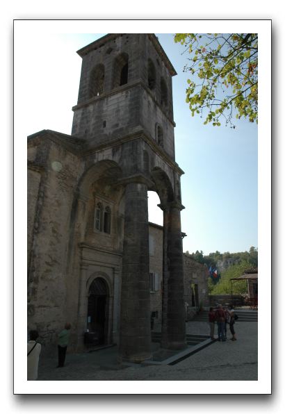 11- - L'église dresse fièrement dans le bleu azur du ciel son surprenant clocher soutenu par d'immenses colonnes 